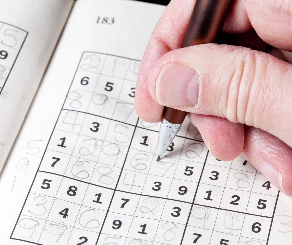 Someone solving a sudoku math puzzle